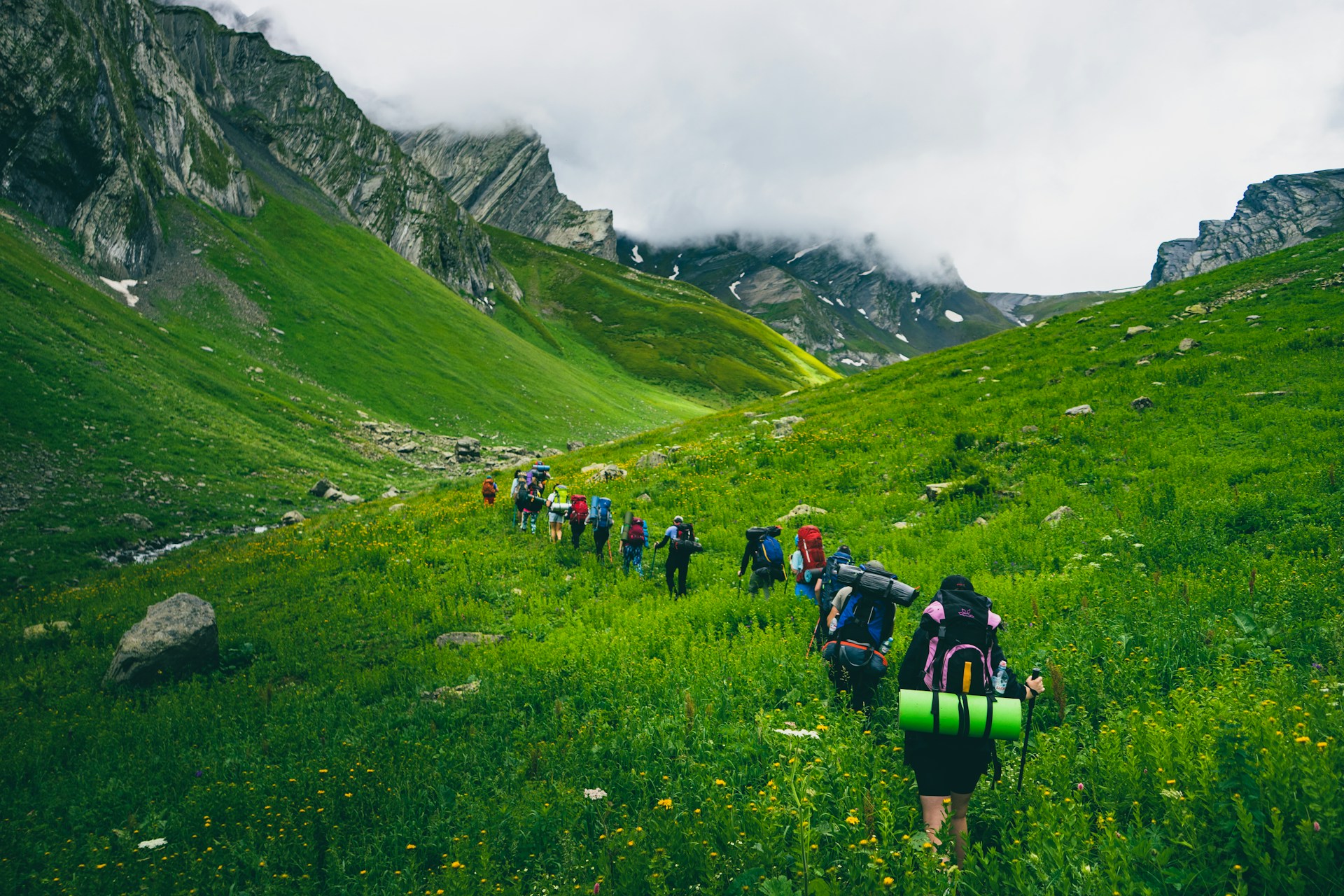 A group of hikers spread out along a mountain trail