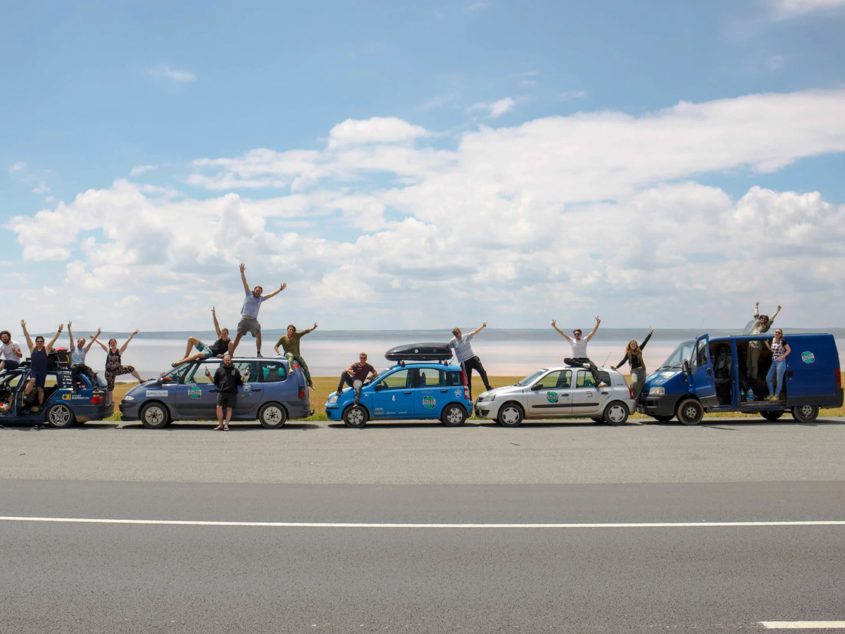A group of friends with their five cars parked by the road on a road trip